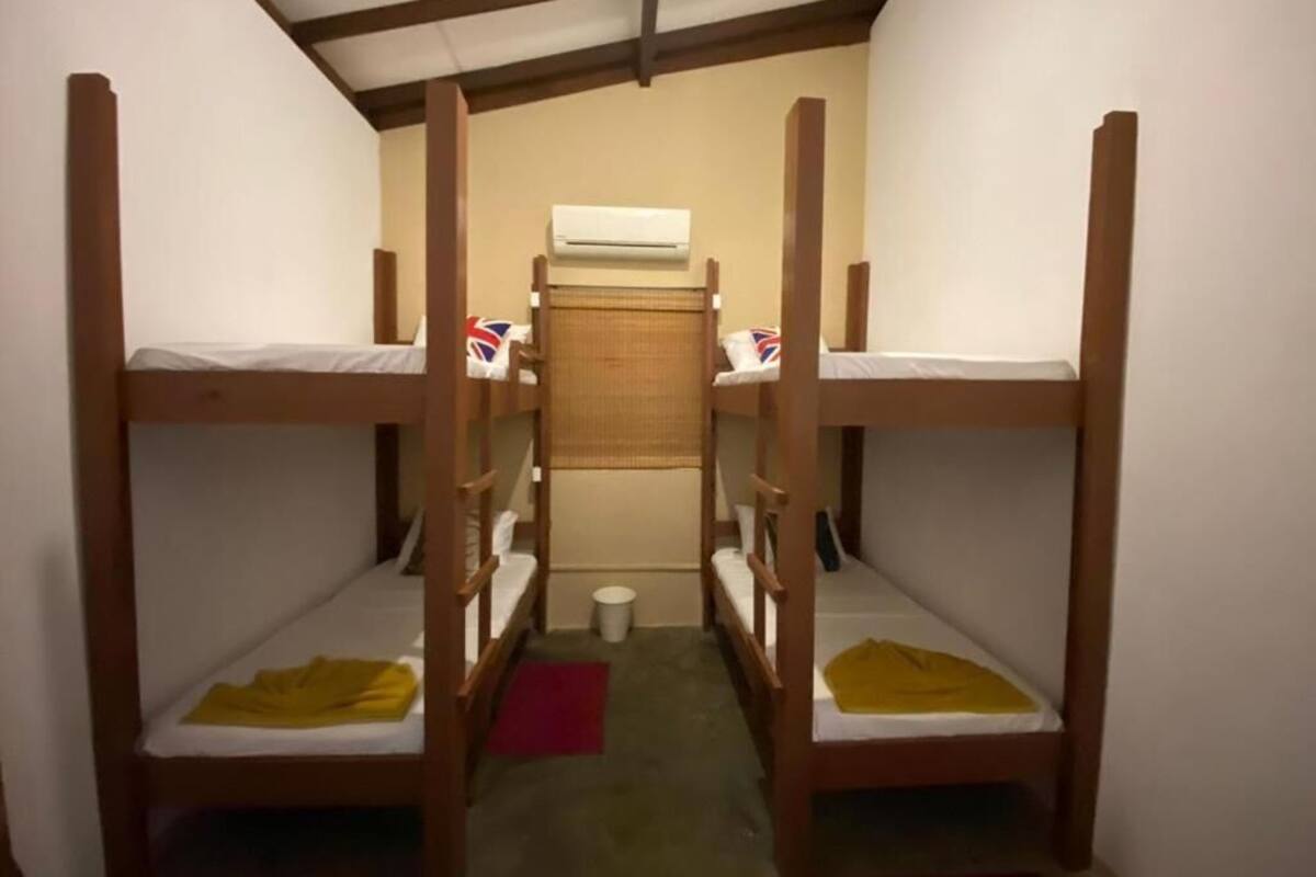A narrow room with bunk beds arranged in two rows.
