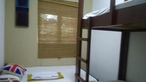 A bunk bed room with a small desk and a window with blinds. - Sanora Hostel (Sigiriya)