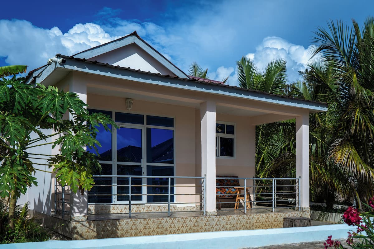 A two-story house with a covered porch, large windows, and a swimming pool.