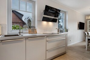 Una cocina moderna con un ventanal grande, electrodomésticos de acero inoxidable y un horno empotrado.