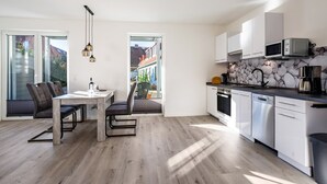 Een moderne keuken met witte kastjes, een ingebouwde magnetron en een vaatwasser.