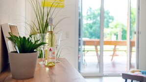 Una mesa con una botella de vino, una copa y una planta en maceta.
