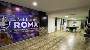 Een hal met een pooltafel en een muur met een bordje voor Villa Roma.