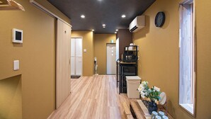 A hallway with wooden flooring, a clock on the wall, and a window on the right. - Travel time Setsugekka (Osaka)