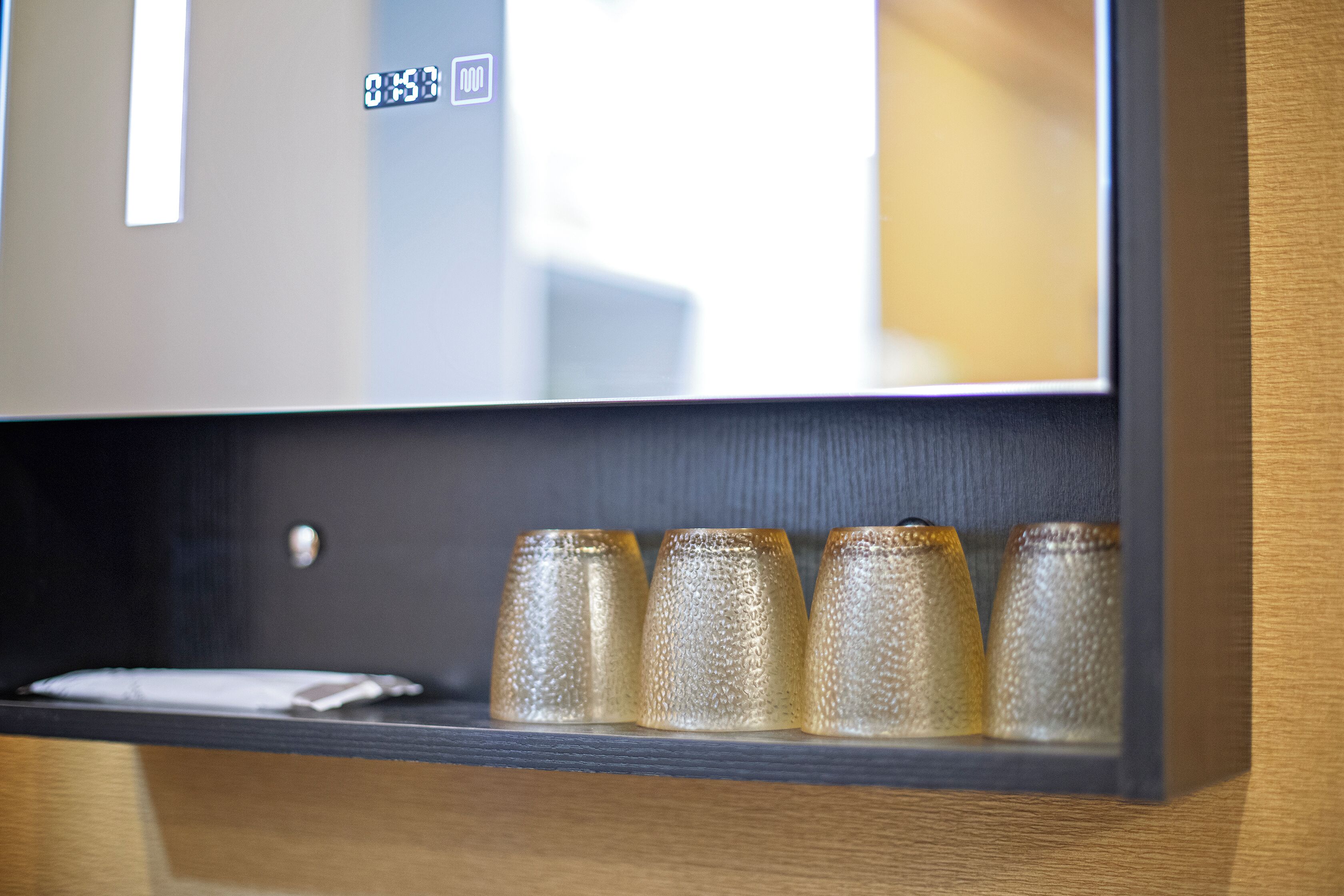 A television mounted on a wooden wall with a digital clock displaying 8:53.