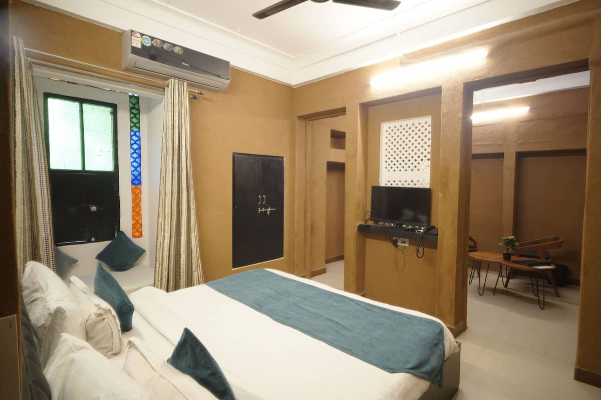 A hotel room with a bed, a television, a desk, and a wardrobe.