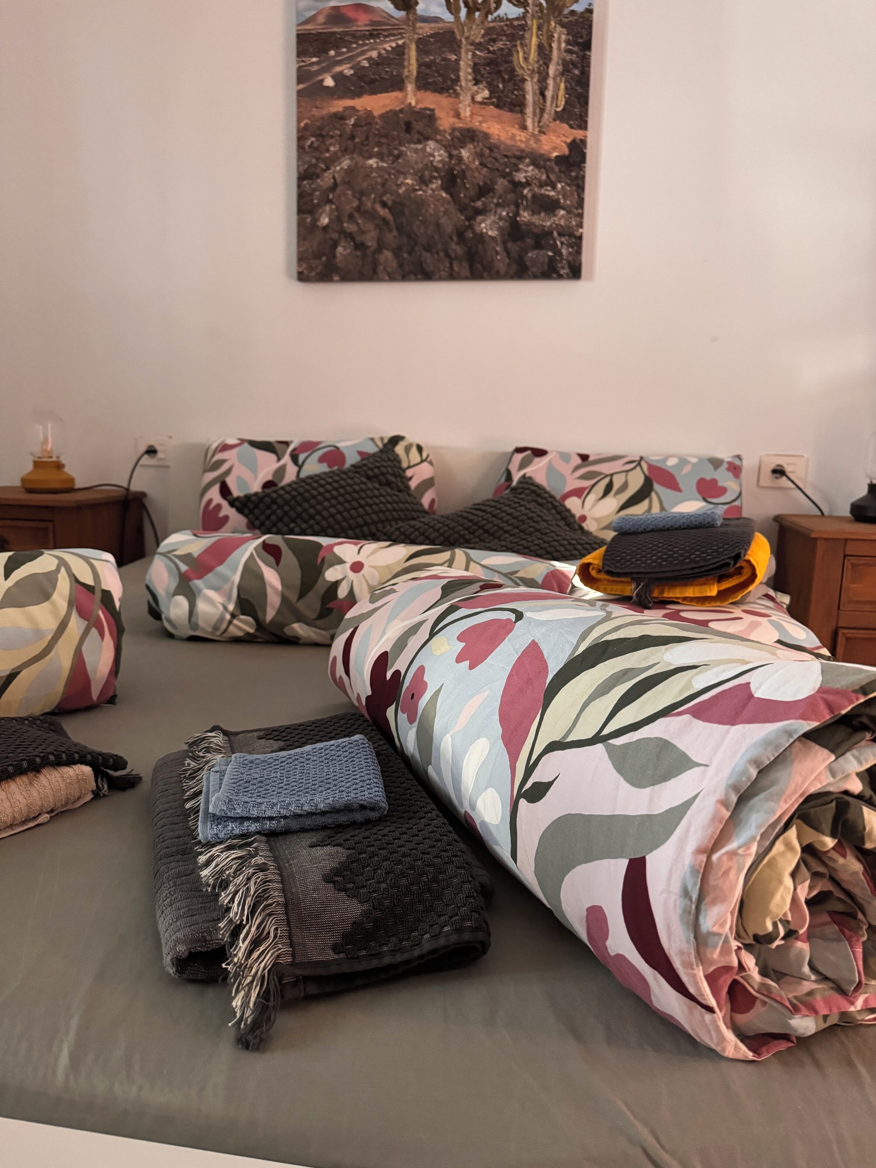 A neatly arranged bedroom with a bed, pillows, and blankets.