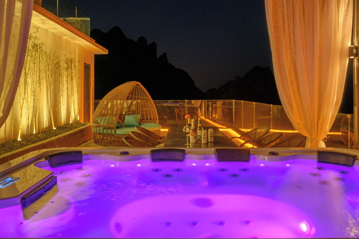 A hot tub area with seating and a view of the mountains.