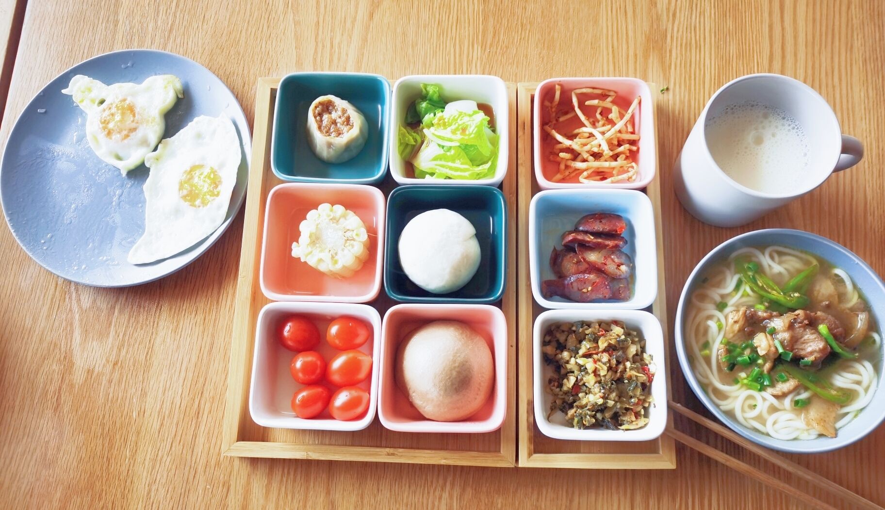 Una comida con diversos platos, incluyendo huevos, verduras y un tazón de sopa.