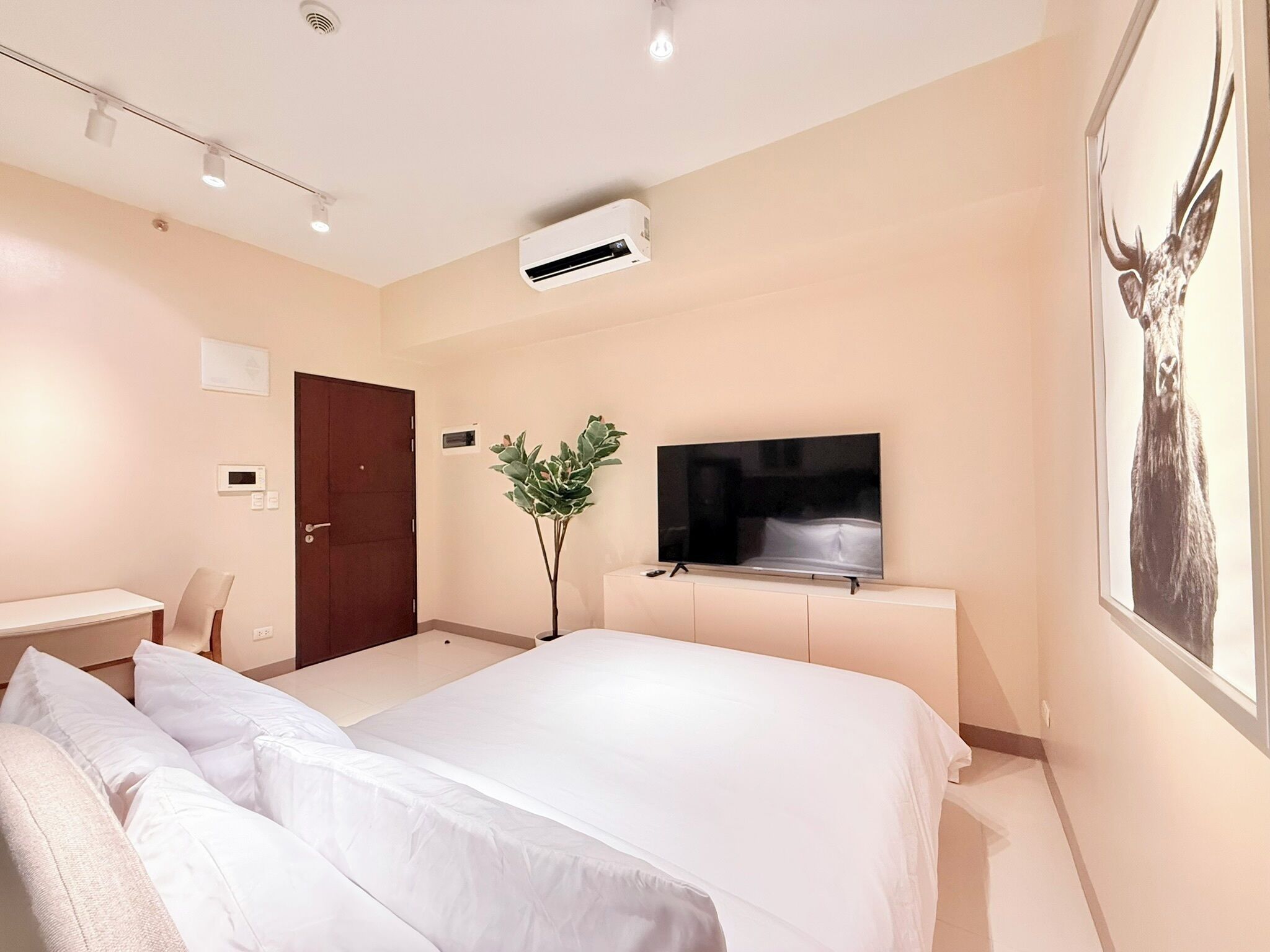 Een moderne hotelkamer met een groot bed, een flatscreen televisie, een bureau en een deur.