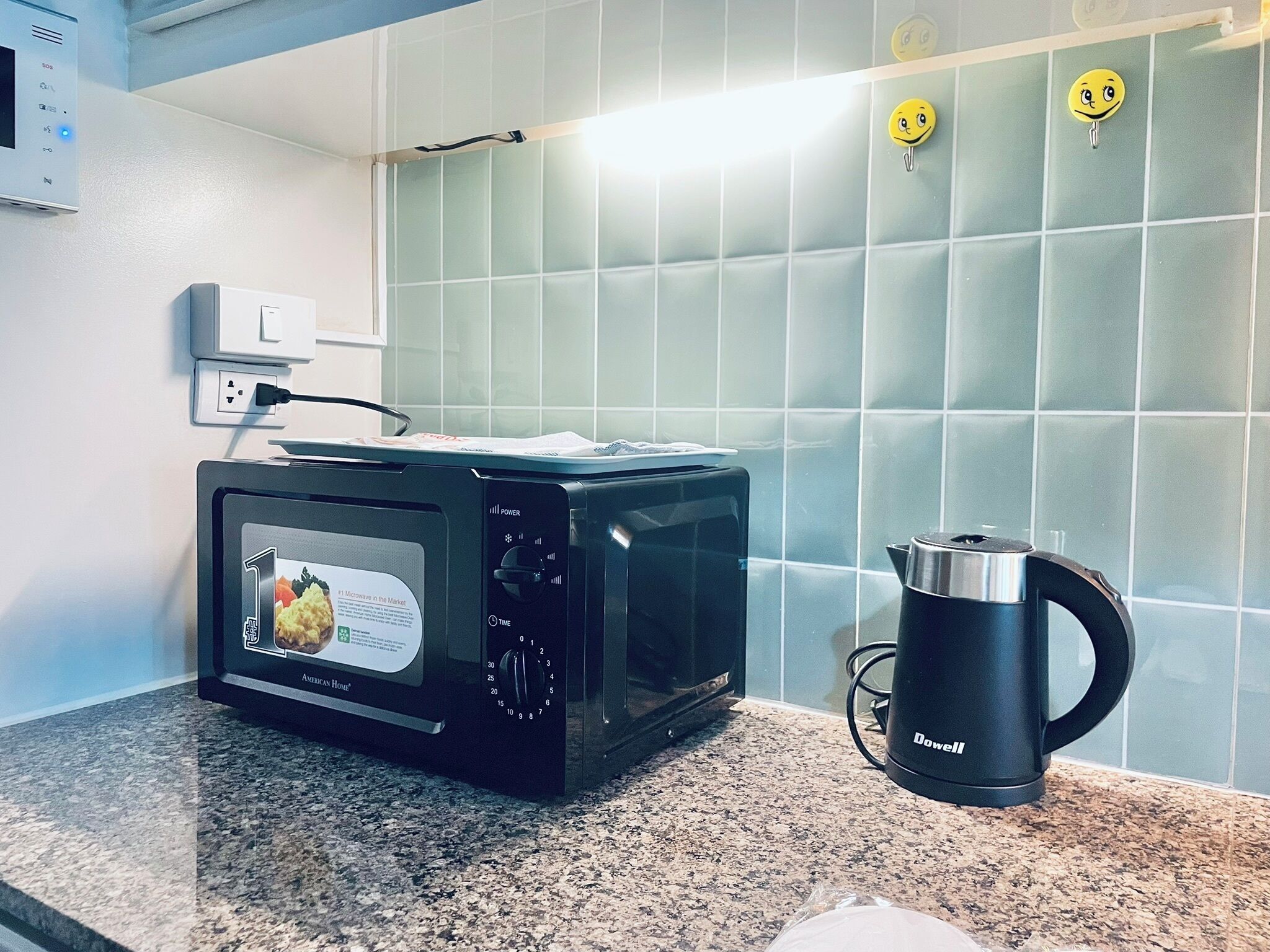 A kitchen with a black toaster oven, a black coffee maker, and a tiled backsplash.