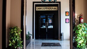 A hotel entrance with a black door, a chandelier, and potted plants. - Nubia real estate aqua beach (Hurghada)