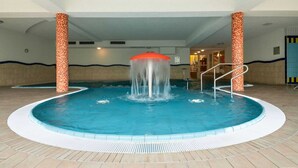 En pool med en central fontän och trappsteg som leder ner i vattnet.