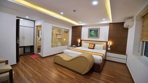 A modern hotel room with a wooden floor, a bed with a headboard, a bedside table, and a wardrobe. - Sac Mau Hotel HN - by Bay Luxury (Hanoi)