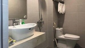 A bathroom with a white sink, mirror, and toilet. - Sac Mau Hotel HN - by Bay Luxury (Hanoi)