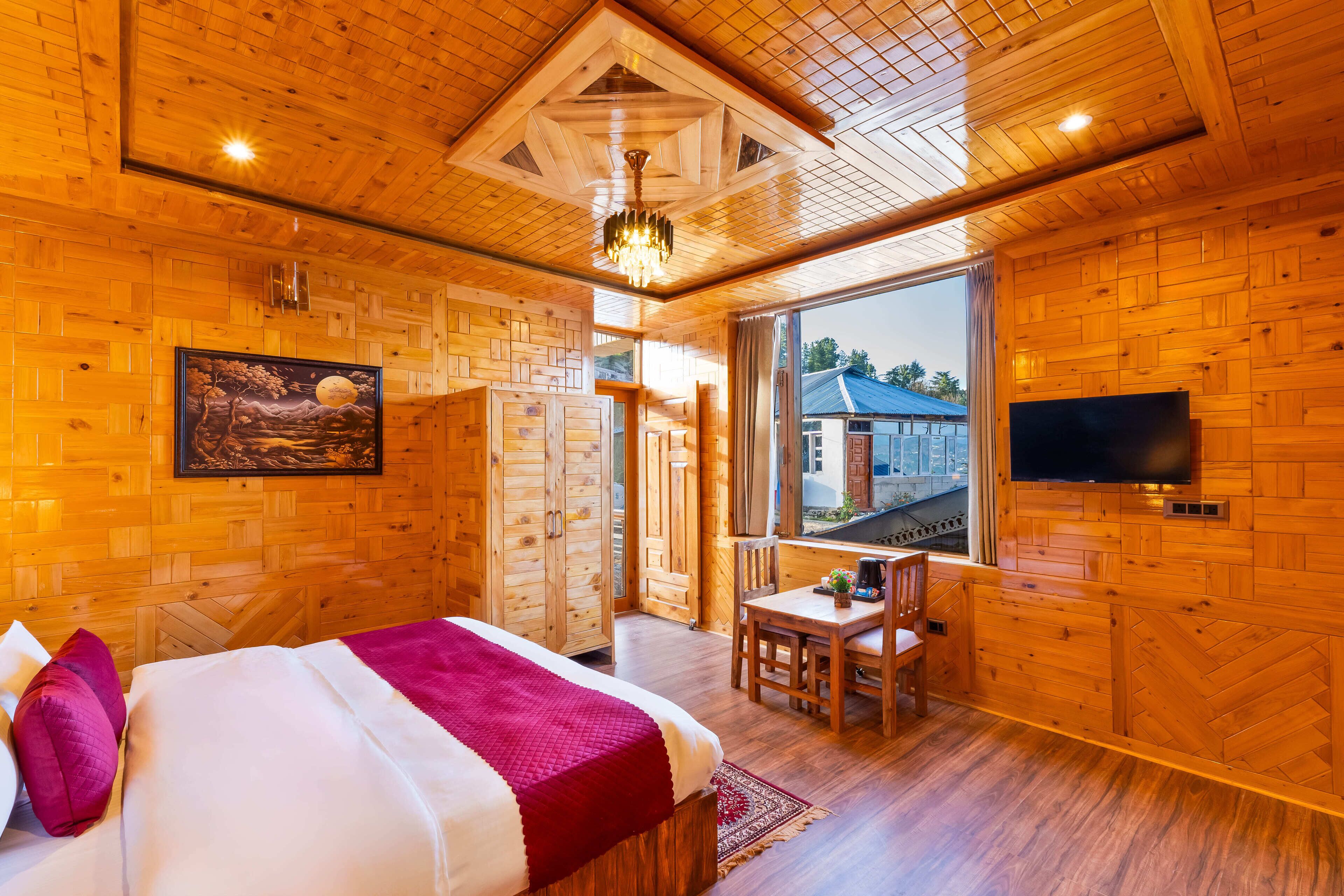 Een houten kamer met een bed, een bureau en een televisie.