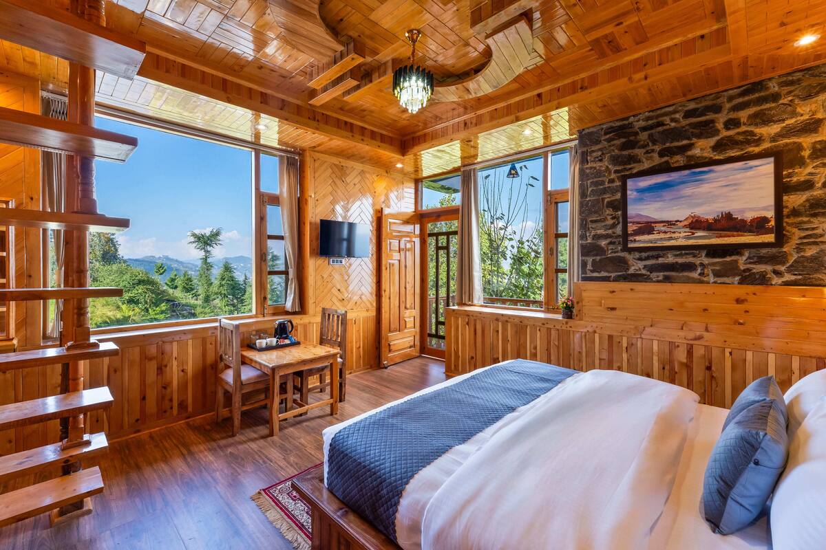 Una cabaña de madera con una cama, un escritorio y un televisor.