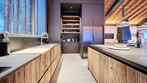 Una cocina moderna con armarios de madera, una isla central y electrodomésticos integrados.