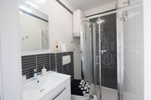 Chuveiro, secador de cabelo, toalhas de banho, sabonete