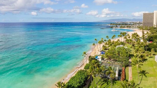 Un hôtel situé sur la côte, avec vue sur la plage, une piscine et un parcours de golf.