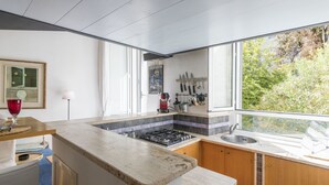 A modern kitchen with a gas stove, a sink, and a window overlooking greenery. - Marsicum by Interhome (Rome: Historical City Center)