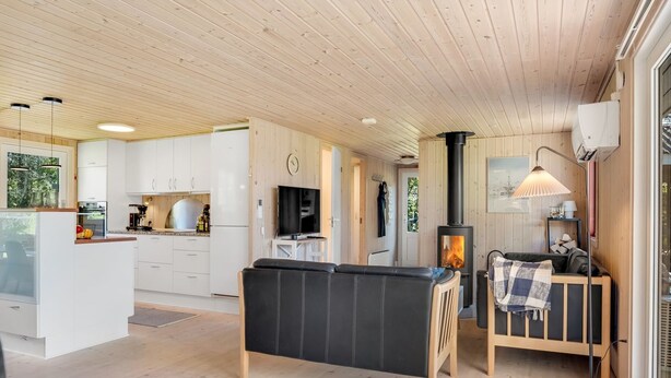 A modern cabin interior with a kitchen, living area, and a wood-burning stove. - "Rajna" - 500m to the fjord by Interhome (Vestervig)