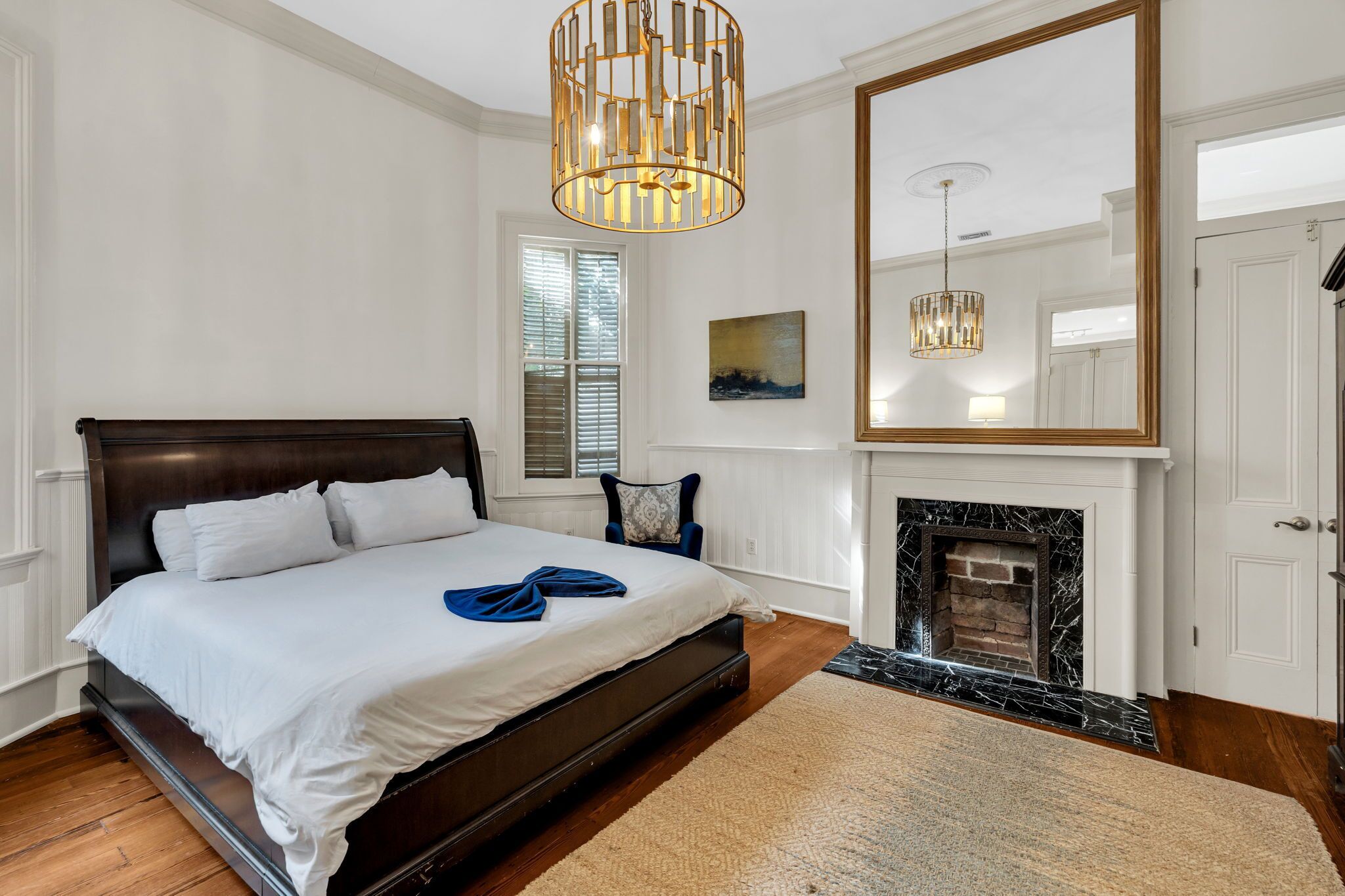 Spacious bedroom w/ rich wood tones & a cozy, refined atmosphere.
