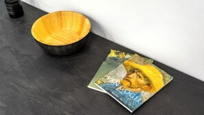 A black bowl and a book titled "WANGOGH" on a dark surface. - 2BRCozy Urban Retreat Exarchia (Athens)