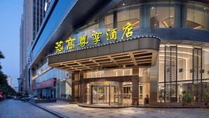 A hotel entrance with a modern design, featuring a glass facade and a prominent illuminated sign. - Li Gao Exclusive Hotel (Changsha)