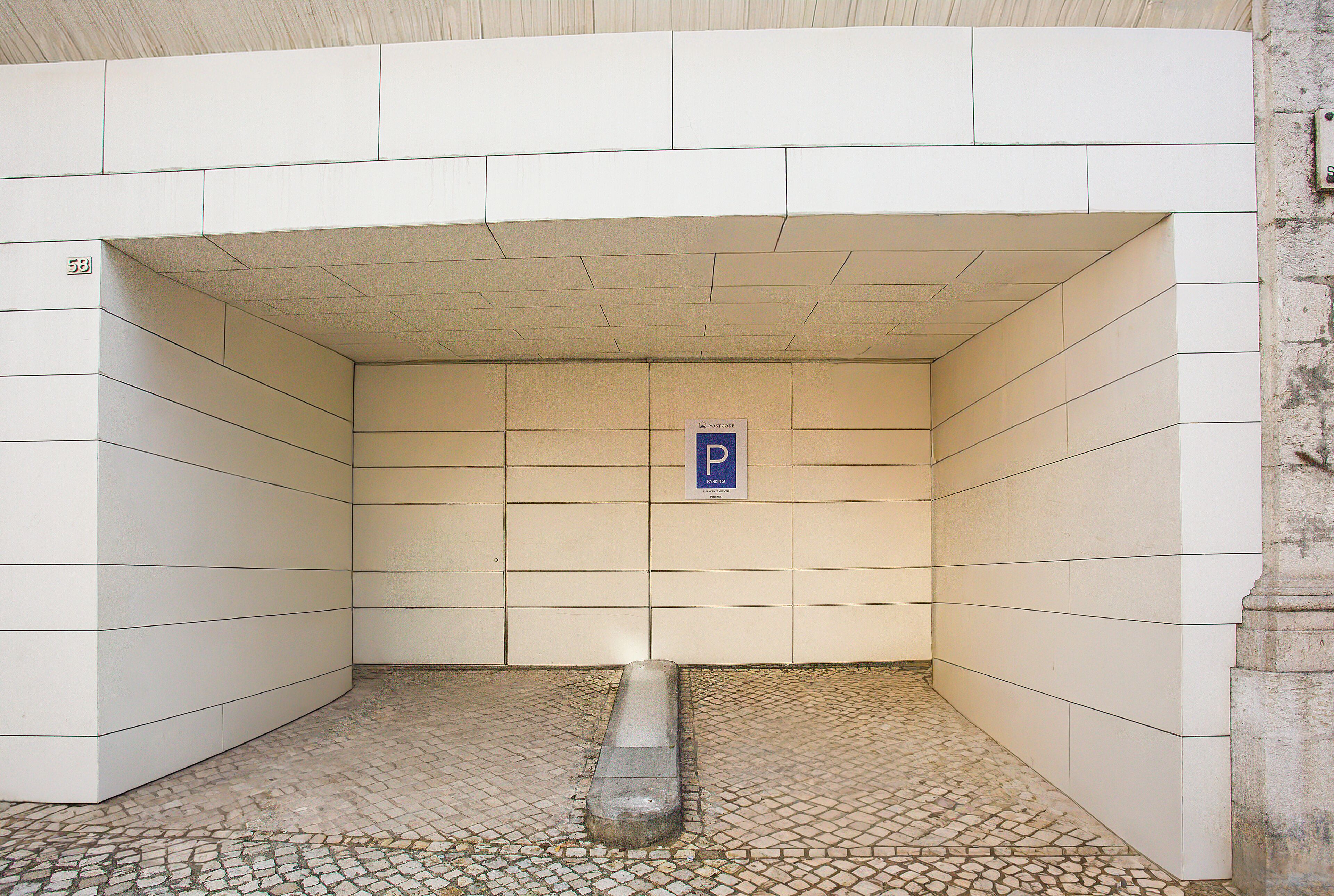 A parking garage with a tiled floor and a blue parking sign.