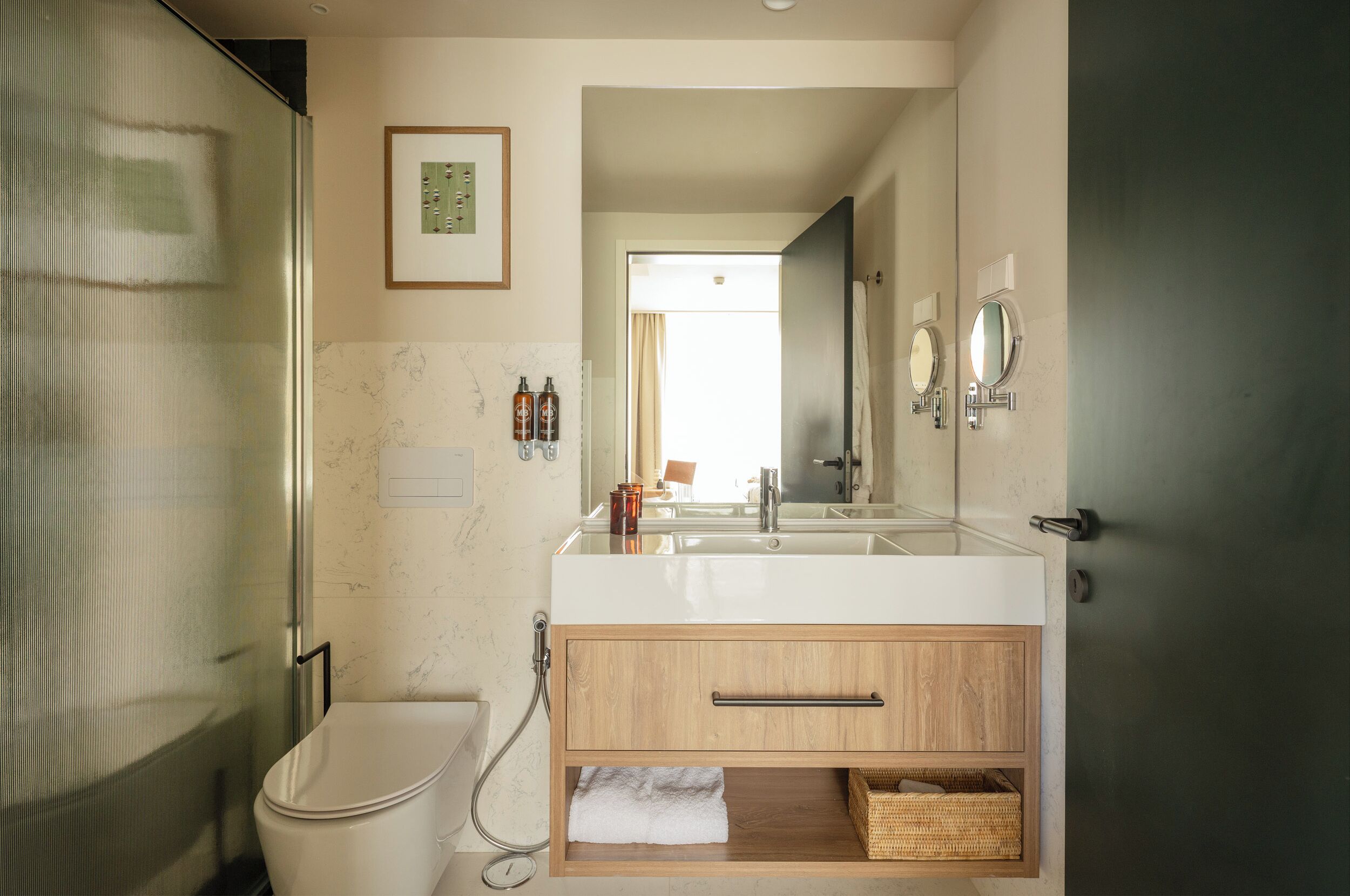 A modern bathroom with a large mirror, a white sink, and a shower enclosure.