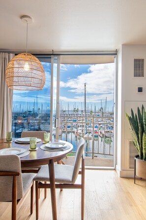 Enjoy meals with a marina view from this dining area featuring a large round table and sliding glass door.