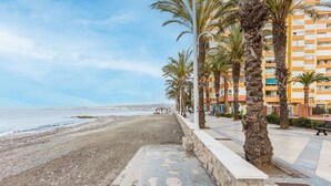 A coastal promenade with a stone pathway, palm trees, and a beach. - A&N Algarrobo Beach Tower (Algarrobo Costa)