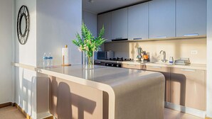 A modern kitchen with a central island, stainless steel appliances, and a minimalist design. - w* | Airy 2BR in San Francisco w/ Pool (Panamá)