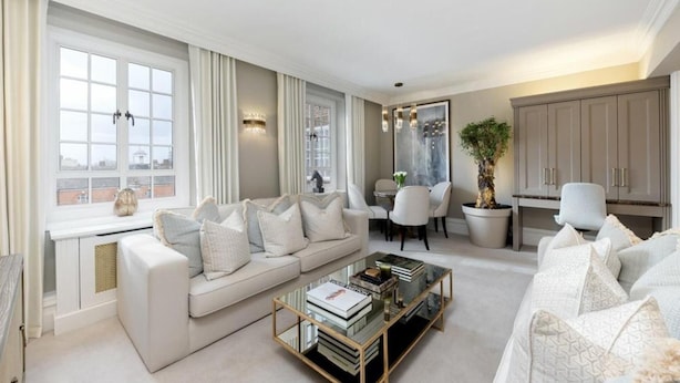 Un salon moderne avec un canapé, une table basse et un coin repas.