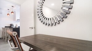 Ein moderner Essbereich mit einem dunklen Holztisch und einem einzigartigen, runden Wandkunstwerk.