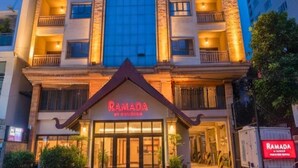 Un hôtel appelé Ramada, doté d’une façade moderne, de grandes fenêtres et d’une entrée imposante.