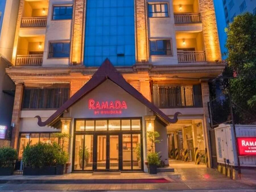 A hotel named Ramada with a modern facade, large windows, and a prominent entrance.