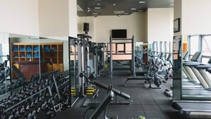 Une salle de sport équipée de divers appareils d’exercice, de tapis de course et de machines de musculation.