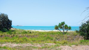 Una playa con vista despejada al océano y una isla distante.