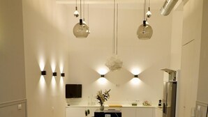 A modern living room with a sofa, a coffee table, and a kitchen in the background. - "Peral boutique Apartments: Cozy apartment in the center of Seville:  (Sevilla)