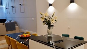 A modern kitchen with a central island, wooden herringbone flooring, and a dining area with yellow chairs. - "Peral boutique Apartments: Cozy apartment in the center of Seville:  (Sevilla)