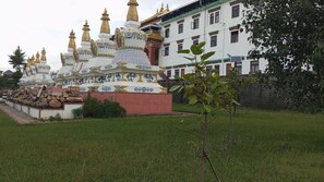 A traditional building with multiple spires, a red base, and a white facade with decorative patterns. - Best Apartments in Bir Billing By# Treasure of Himalayas House# Cheapest Apartment In Bir billing# Bir billing distance 15 KM #baijnath temple 2 KM# Rooftop Cafe #home made food (Baijnath)