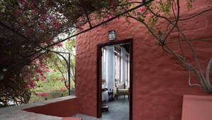 Ein Zimmer mit Blick auf einen Garten, ein Fenster und eine Tür, die in einen anderen Raum führt.