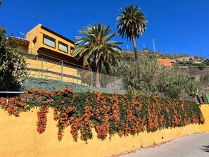 Surrounded by lush greenery, this residential area offers a serene escape with a balcony overlooking the hillside.