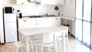 A modern kitchen with white cabinets, a gas stove, a microwave, and a sink. - Brembate Comfort Home (Brembate)