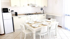 A modern kitchen with white cabinetry, a gas stove, a microwave, and a refrigerator. - Brembate Comfort Home (Brembate)