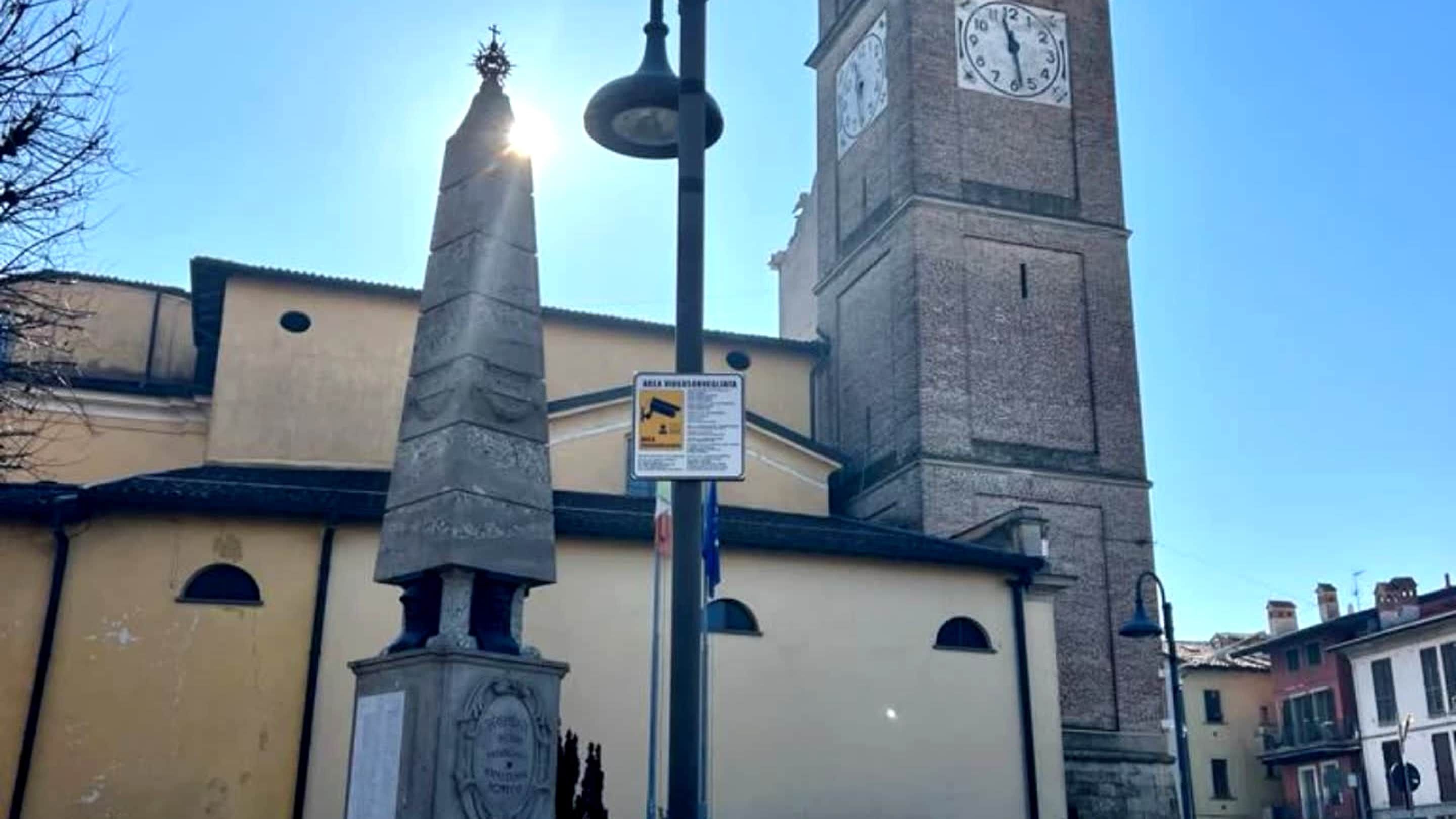 Ein Glockenturm, eine Statue und eine Gebäudefassade.