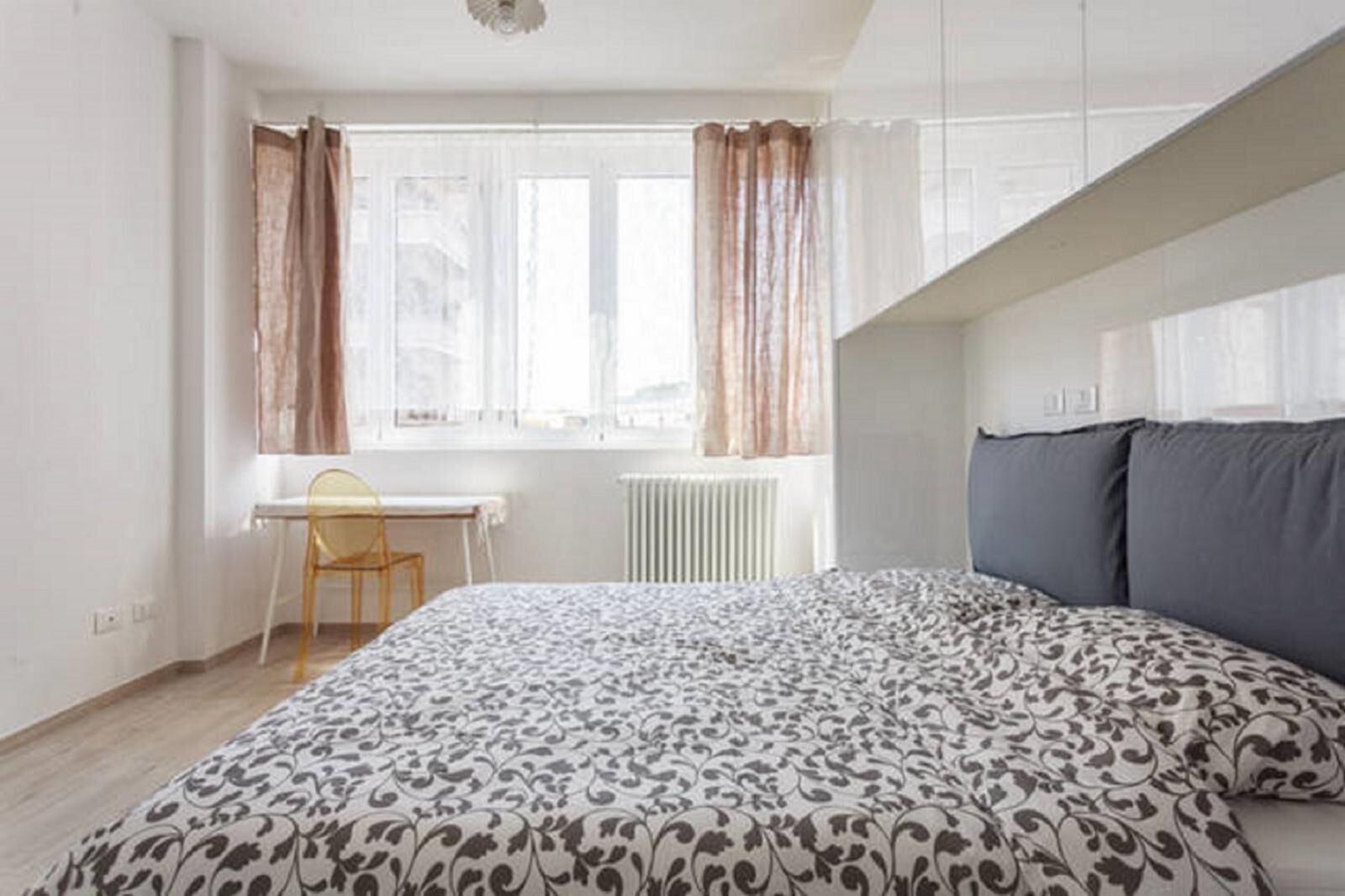 Ein Schlafzimmer mit einem Bett, einem Schreibtisch und einem Stuhl.
