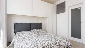 Ein Schlafzimmer mit einem Bett, einem weißen Kleiderschrank und einer Tür.